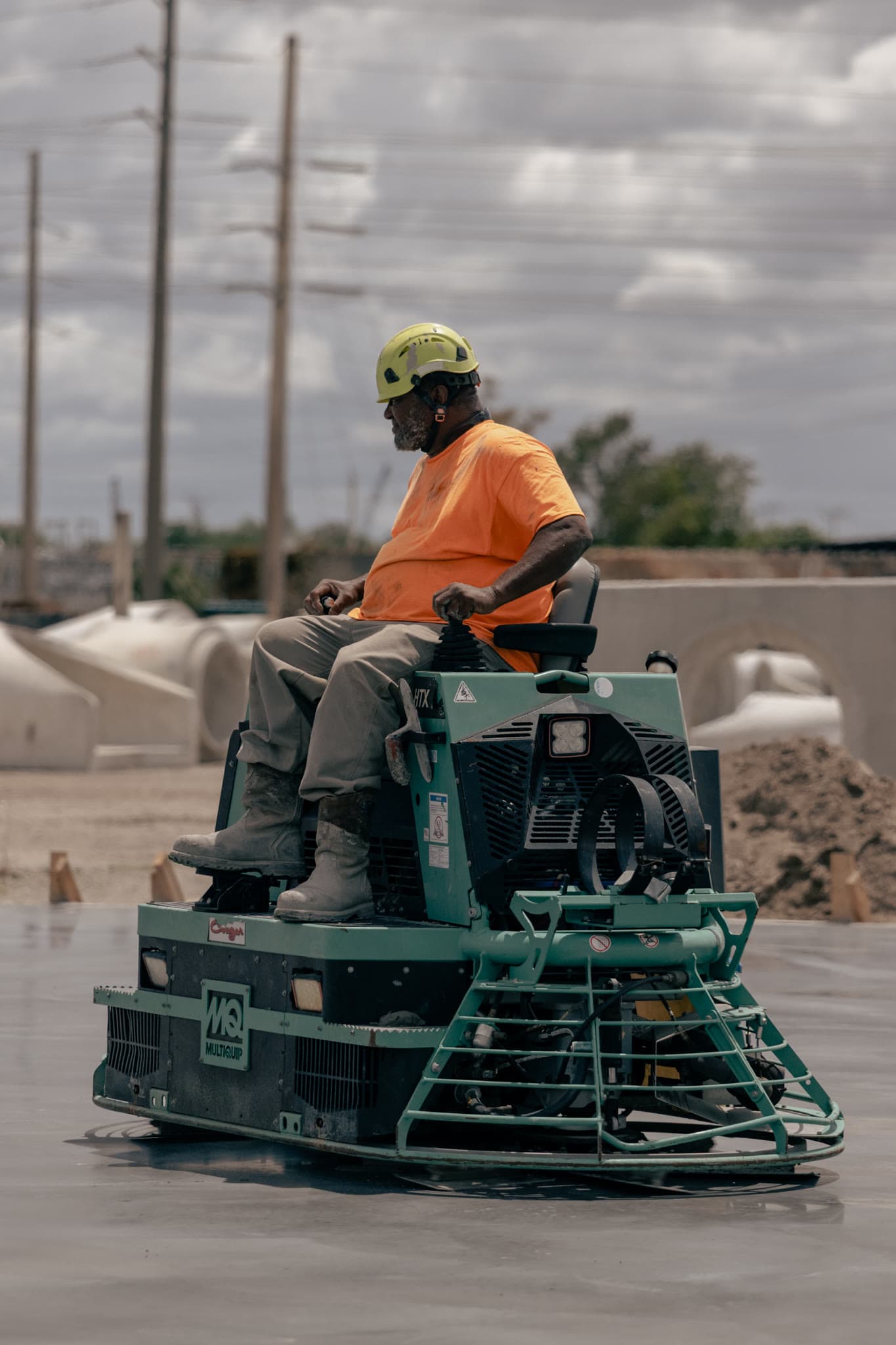 Operator smoothing the Foley Products facility slab with a ride-on power trowel