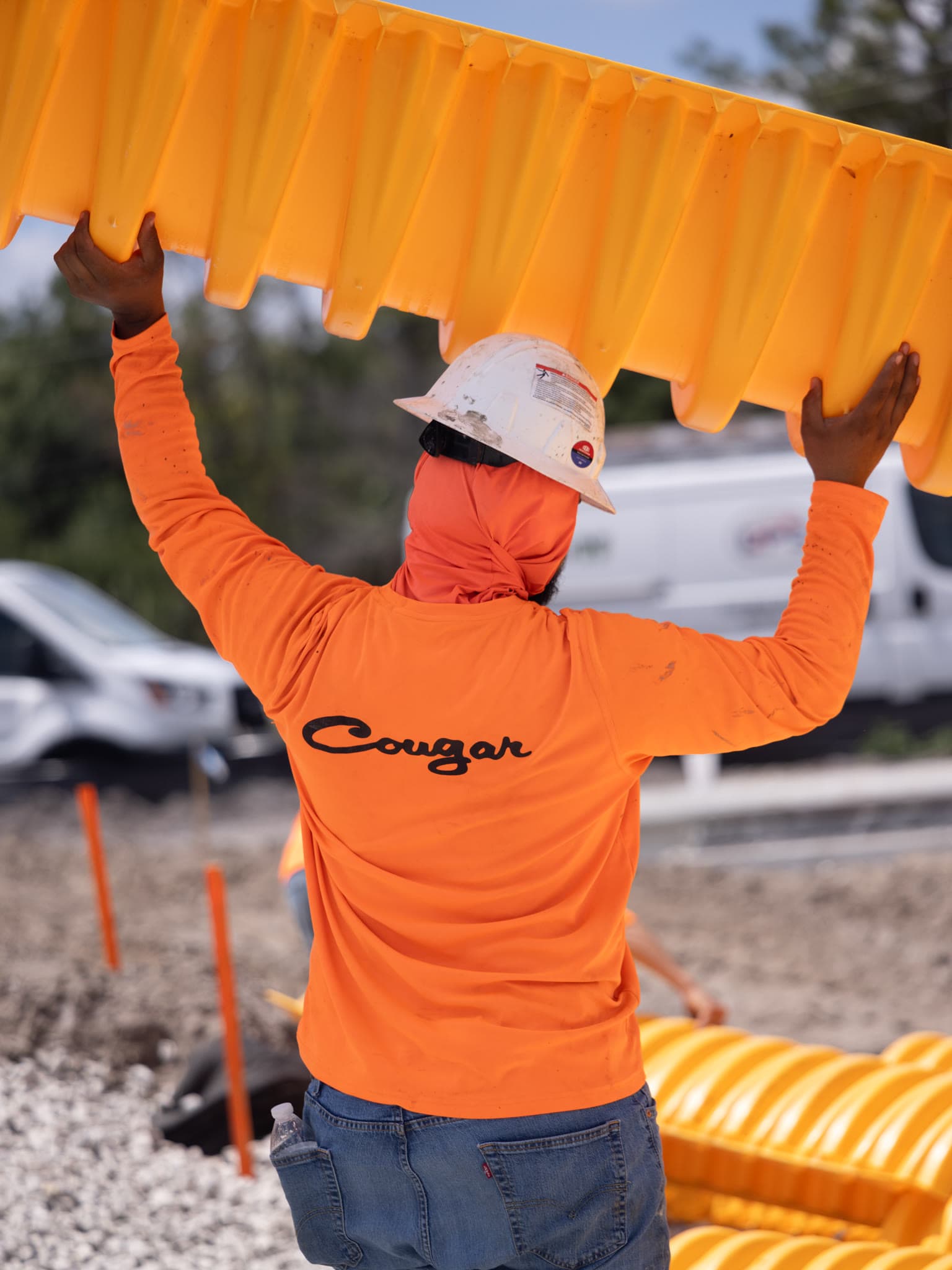 Crew member carrying a stormwater chamber section at the RaceTrac site in North Fort Myers
